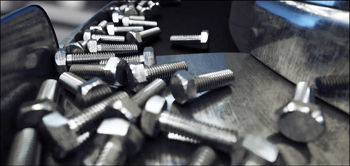 Steel hex bolts on a metal work surface